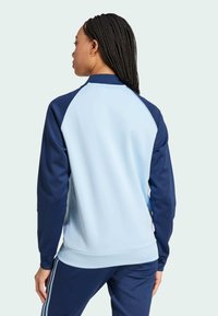 adidas Originals ADICOLOR CLASSICS SUPERSTAR TRACK - Vetoketjullinen college - clear sky