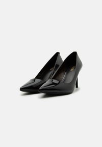 Escarpins en cuir verni noir à talons hauts avec un design à bout pointu, texture lisse et un talon aiguille fin. L'intérieur présente une doublure à motif subtil.