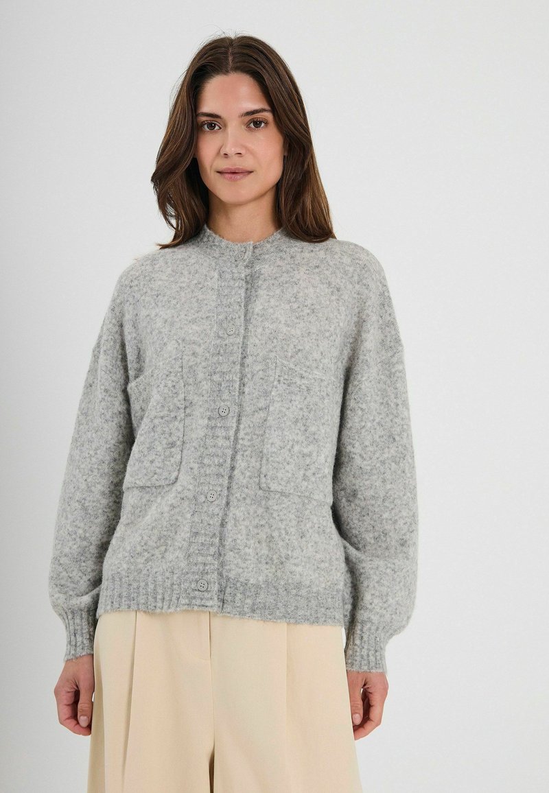 Szary wełniany kardigan z okrągłym dekoltem, z przodu na guziki, z dwiema dużymi kieszeniami i ściągaczami na mankietach. Miękka tekstura, luźny krój i minimalistyczny design.