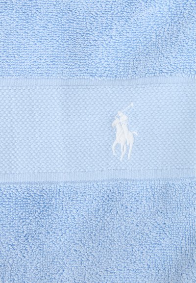 Πετσέτα γαλάζια με υφή, με υφαντή ζώνη που φιλοξενεί λογότυπο λευκού κεντημένου παίκτη πόλο επάνω σε άλογο.