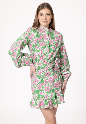 Floral dress in green with pink flowers, featuring a high neckline, long puff sleeves, a fitted waist, and a ruffled hem.