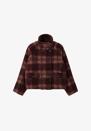 Veste cropped double boutonnage en motif tartan bordeaux et marron, avec un col haut, de grandes poches avant et des boutons en métal.