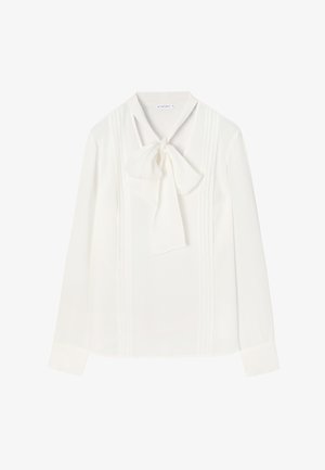 Bílá dlouhá blůza s dlouhým rukávem, která má mašli na výstřihu, vertikální jemné skladby a lehkou, hladkou texturu látky.