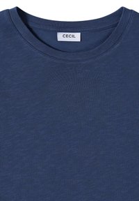 Mørkeblå t-shirt med rund halsudskæring og en hvid label syet ind i kraven med mærket "CECIL".
