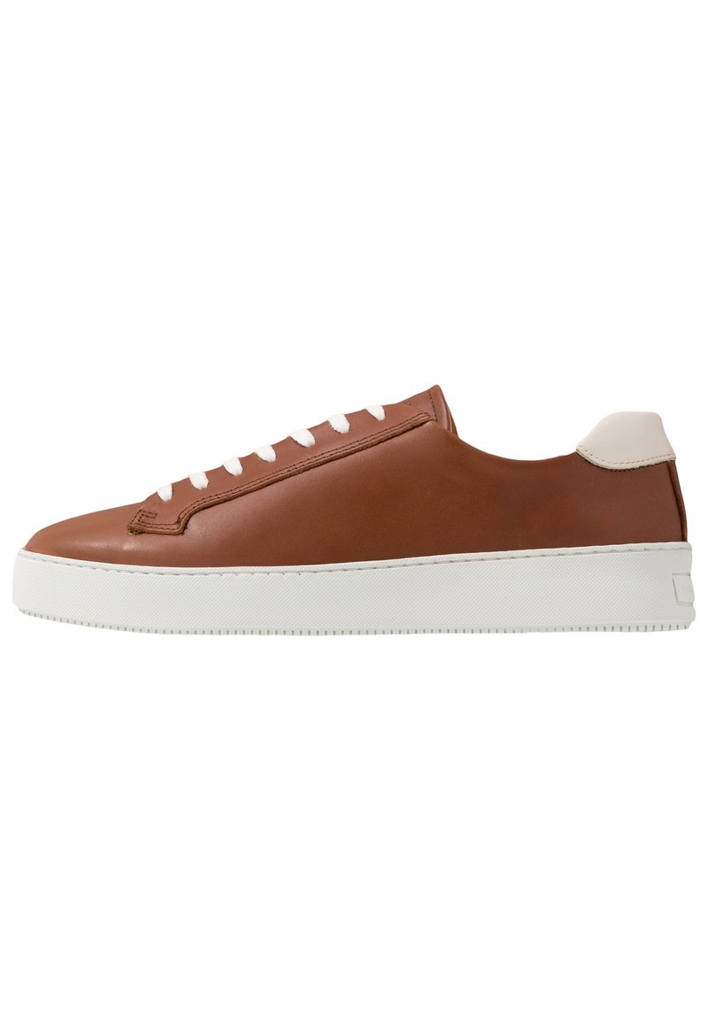 Bruna lädersneakers med vit gummisula, med minimalistisk design, platta snörning och en liten beige detalj vid hälen.