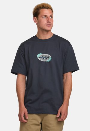 Camiseta de algodón azul marino con mangas cortas y cuello redondo. Presenta un gráfico de olas estilizadas en tonos verde azulado y blanco en la parte delantera.