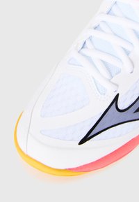 White athletic shoe with mesh panels, light blue accents, and a colorful sole featuring yellow, pink, and orange elements. Black detailing visible.