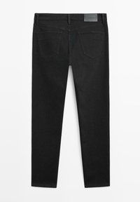 Czarne jeansy o wąskim kroju z dwoma tylnymi kieszeniami i szlufkami na pasek, ułożone na płasko, pokazujące tylną stronę na białym tle.