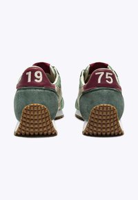 Sneakers in suede verde con accenti bordeaux, presentano numeri ricamati bianchi 19 e 75 sui talloni, suola in gomma testurizzata.