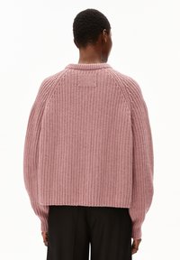 Chunky knitted sweater in soft pink, featuring a wide ribbed texture, raglan sleeves, and a banded collar. Back view shows relaxed fit.