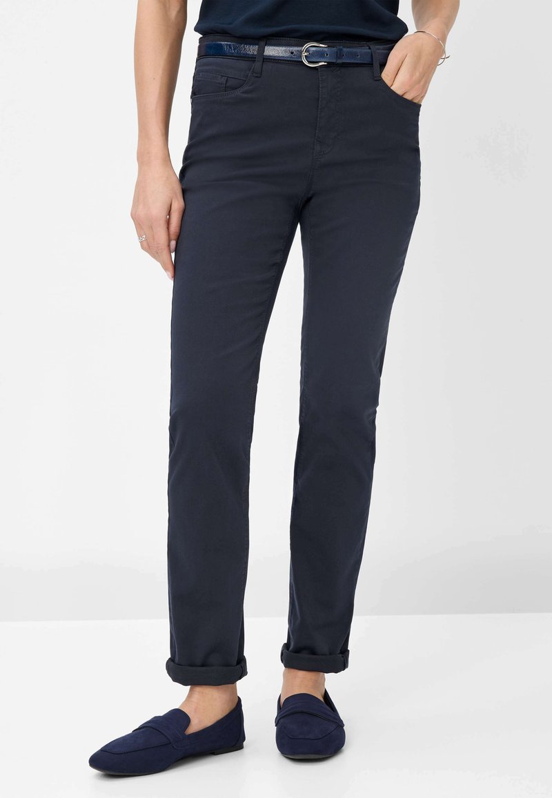 Dunkelblaue Hose aus einem Baumwollmischgewebe, schlanke Passform, mit einem Gürtel mit glänzender silberner Schnalle, umgeschlagenen Säumen und Fronttaschen.