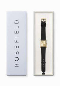 Reloj con correa de cuero negro, caja rectangular en tono dorado y un dial minimalista de color dorado claro, presentado en una caja azul clara con la marca "ROSEFIELD".