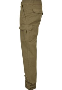 Vue latérale d'un pantalon cargo marron avec passants pour ceinture, poches zippées et deux poches à rabat sur la cuisse et la hanche.