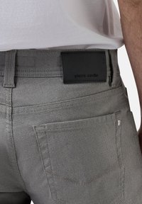 Grijze denim jeans met een gestructureerde stof, voorzien van een zwart leren label op de tailleband en twee achterzakken met contrasterende stiksels.
