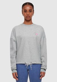 Grijze sweatshirt met een ontspannen pasvorm, ronde halslijn en een trekkoord onderaan. Bevat een eenvoudige roze flamingo borduursel op de borst.