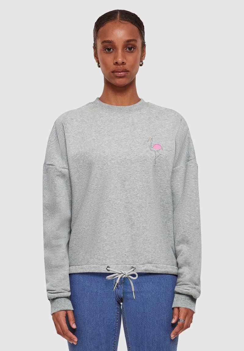 Grijze sweatshirt met een ontspannen pasvorm, ronde halslijn en een trekkoord onderaan. Bevat een eenvoudige roze flamingo borduursel op de borst.