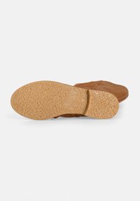 Scarpa in pelle marrone con suola in gomma tan flessibile e strutturata. La suola presenta un motivo sottile ed è progettata per il comfort e la presa.