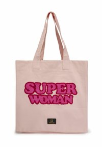Sac en toile rose avec un texte flou et audacieux "SUPER WOMAN" en fibres roses texturées, avec une petite étiquette noire en bas.