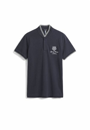 Mornarsko plava polo majica kratkih rukava s bijelim prugastim ovratnikom i manšetama, vezeni grb i natpis "Antony Morale" na lijevoj strani prsa.