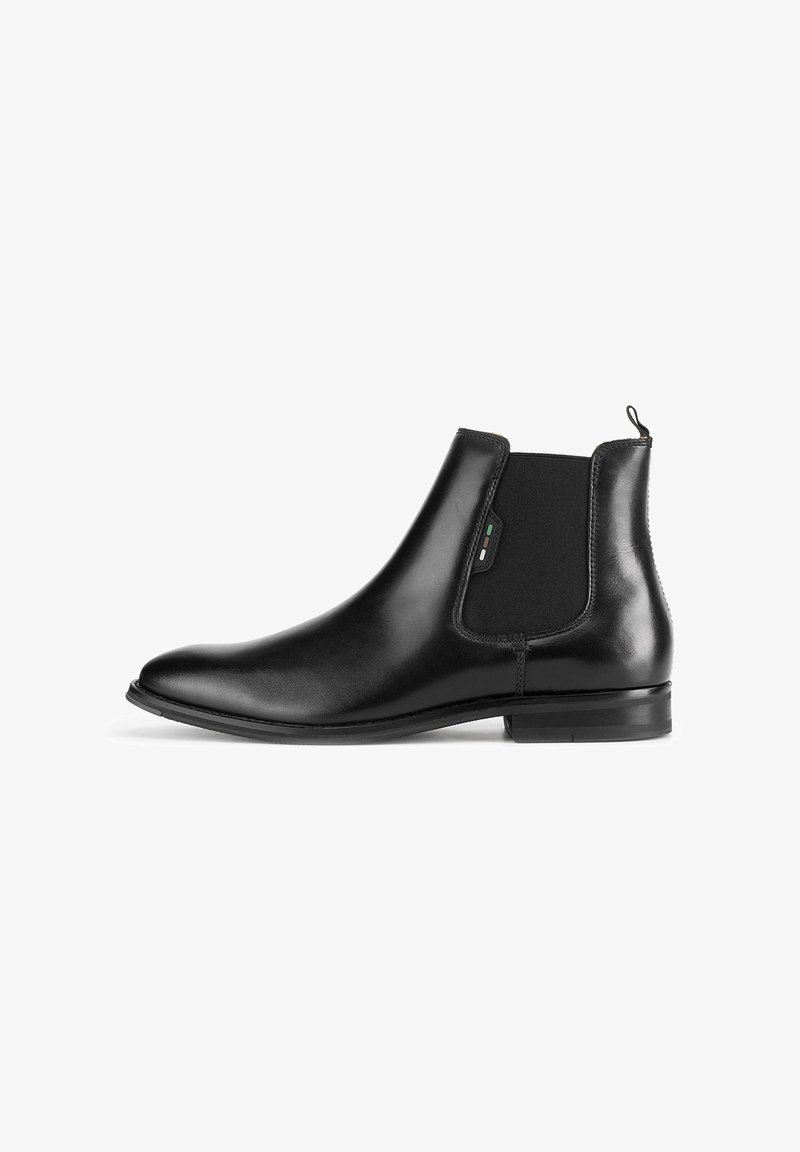 Bota Chelsea de cuero negro con paneles laterales elásticos, puntera redondeada, acabado elegante y una pequeña lengüeta en la parte trasera para facilitar el calzado.