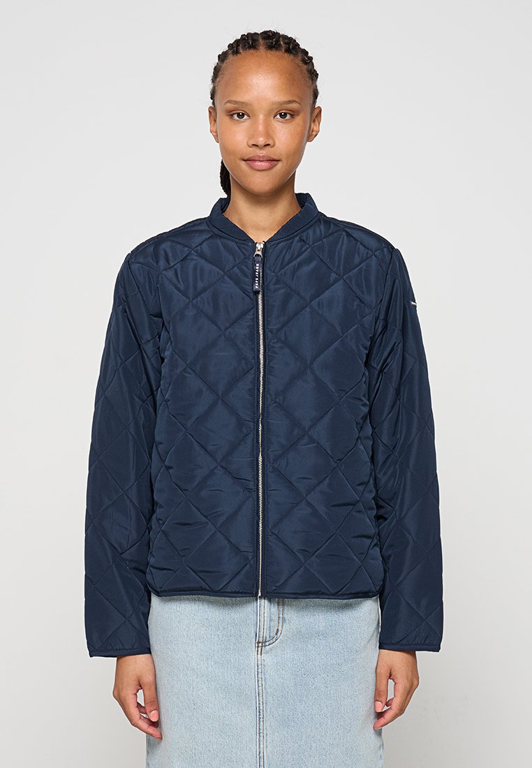 Chaqueta bomber acolchada de color marino con cremallera frontal, cuello alzado y mangas largas. Presenta un patrón de diamantes y una textura suave y brillante.
