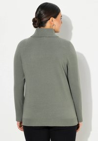 Grauer Pullover aus weichem Strickstoff, mit Kragen, langen Ärmeln und einem lässigen Schnitt, der mit strukturierten Akzenten am Saum versehen ist.