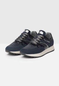 Námořnické modré tenisky se směsicí semiše a lakovaných materiálů, s kovovými akcenty, vzorovanou síťovinou, silnou šedou podrážkou a kontrastními tkaničkami.