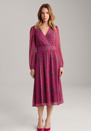 Fuchsia Wickelkleid mit langen Ärmeln, das ein gewelltes Muster in Dunkelgrau aufweist. Fließende Silhouette mit gerafftem Taillenbereich.