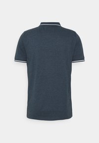 Camisa polo azul marino con un acabado texturizado, mangas cortas, franjas de acento blancas en el cuello y los puños, y un dobladillo recto clásico.