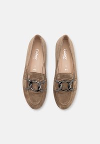 Hnědé semišové slip-on boty s dekoračním černým řetízkem přes nárt. Texturovaný povrch a tvarovaný design.