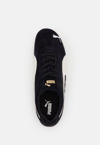 Baskets Puma noir et blanc vues de dessus avec des lacets noirs et le logo Puma sur la languette et la zone des orteils.
