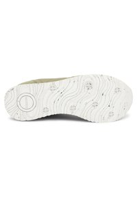White rubber shoe sole with wave texture and circular patterns. Light green upper section partially visible, made of textured material.