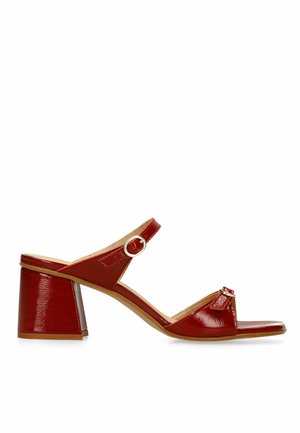 Sandale femme en cuir verni rouge avec talon bloc, bride de cheville ajustable avec boucle et design à bout ouvert sur fond blanc.