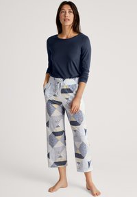 Marineblauwe lange mouwen top gecombineerd met patroonloze, losse broek met driehoeken in blauw, geel en wit. Elastische taille met trekkoord.