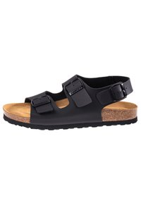 Sandalias negras con plantilla de corcho, correas ajustables con hebillas, diseño de punta abierta y suela de goma con una textura suave y forma moderna.