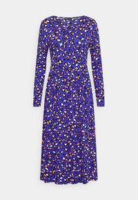 Långärmad klänning i lila med ett flerfärgat leopardmönster som har svarta, orange och vita fläckar. Utskuren nederdel.