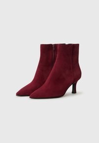 Bottines en daim bordeaux avec un bout pointu, fermeture éclair et un talon effilé et élégant. Texture lisse avec une finition mate.
