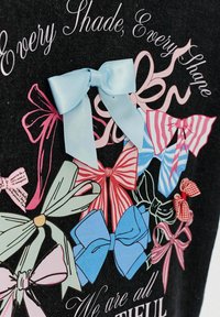 Grafika przedstawia wiele kokard w różnych kolorach i wzorach, w tym jednolitych, w paski i w kratkę, na czarnym tle.