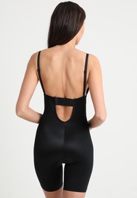 Crni spandex bodysuit s podešivim trakama, otvorenim leđima i bezšavnom donjom strukturom. Ima kopču na kukicu i glatku teksturu.