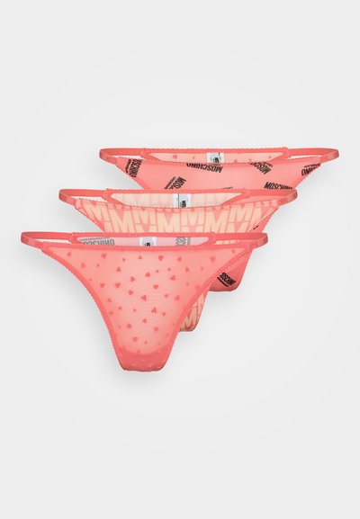 Tre rosa thong truser har en gjennomsiktig design med hjerteformede mønstre på fronten. Livremmen har et merket logo langs kanten.