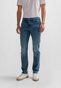 Blå denimjeans med rak passform, med en klassisk femficksdesign, metallknappstängning och subtil blekning fram.