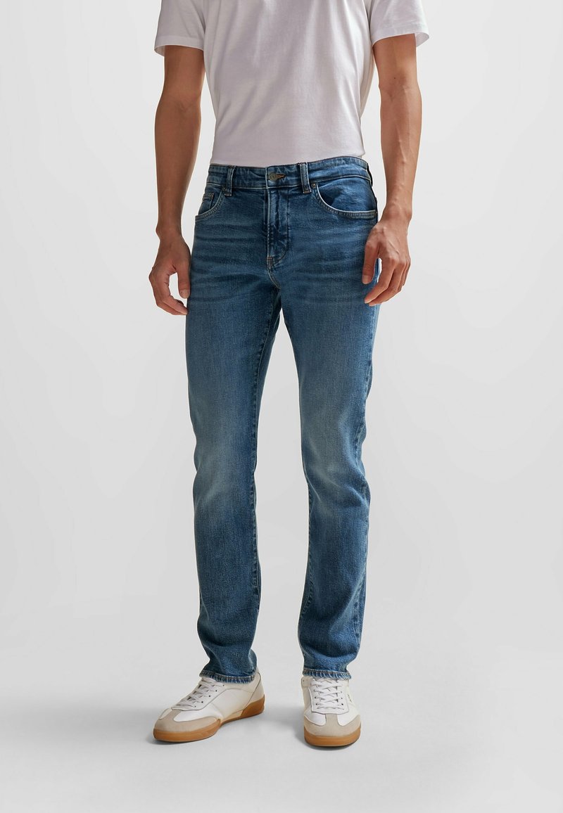 Blå denimjeans med rak passform, med en klassisk femficksdesign, metallknappstängning och subtil blekning fram.