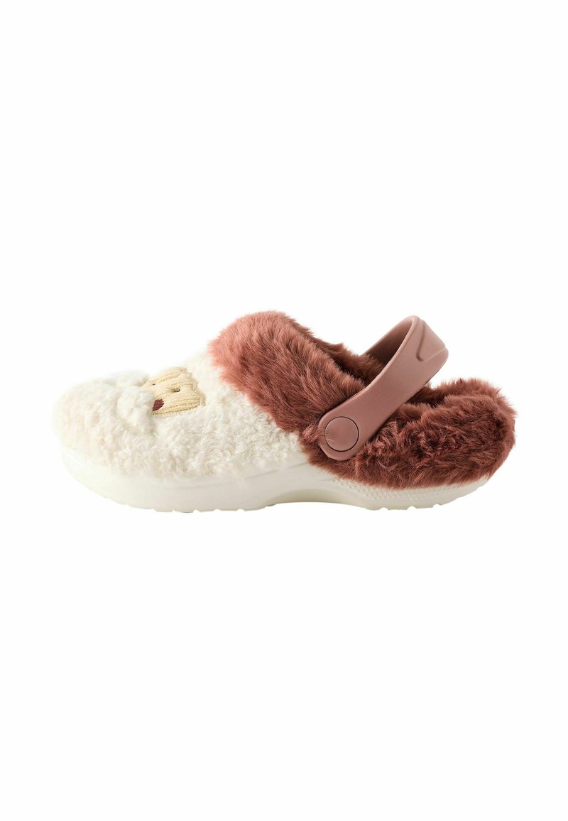 Sabots en peluche avec de la fausse fourrure crème et marron, arborant un visage de cartoon, une sangle rose réglable et une semelle blanche texturée.