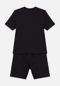 Conjunto de camiseta y pantalones cortos de algodón negro. La camiseta tiene mangas cortas y un escote redondo. Los pantalones cortos llegan hasta la rodilla y cuentan con una cintura elástica.