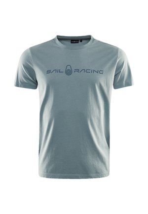 Lyseblå bomulds t-shirt med korte ærmer og rund hals, med "SAIL RACING" trykt i mørkeblå hen over brystet. Blød tekstur.
