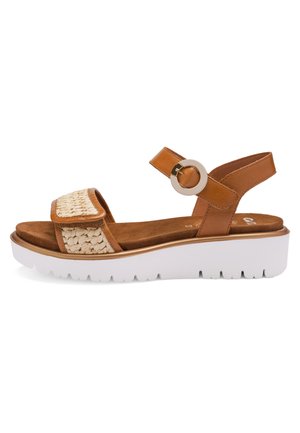 Brun lædersandal med flettet frontrem, rund spændeankelrem, polstret indlægssål og tyk hvid sål med slidbanemønster.