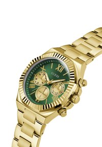 Gold-tone guess watch with a green textured dial, three small subdials, gold accents, and a polished link bracelet. Features bold hour markers.