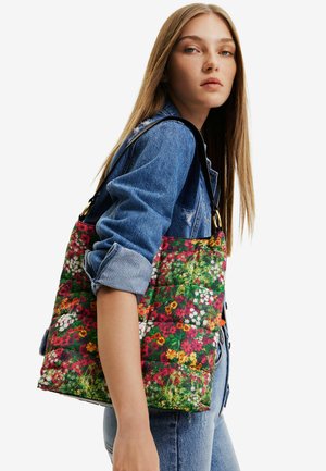 Sac fourre-tout à motif floral avec une texture matelassée aux couleurs vives, doté d'une sangle noire et d'accents métalliques dorés.
