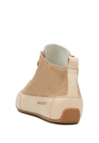 Stivaletto beige in suede con suola in pelle liscia color crema, dotato di punta rotonda e con un logo discreto su un lato. Suola in gomma testurizzata.