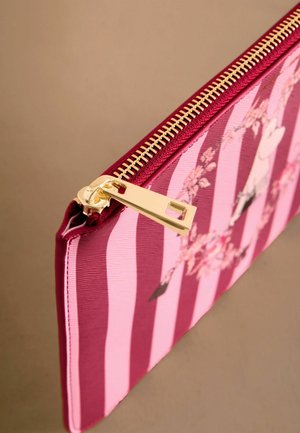 Kapsa na zip v červeno-růžovém pruhovaném látkovém provedení, zdobená květinovými vzory. Zlatý zip přidává kontrast k texturovanému povrchu.